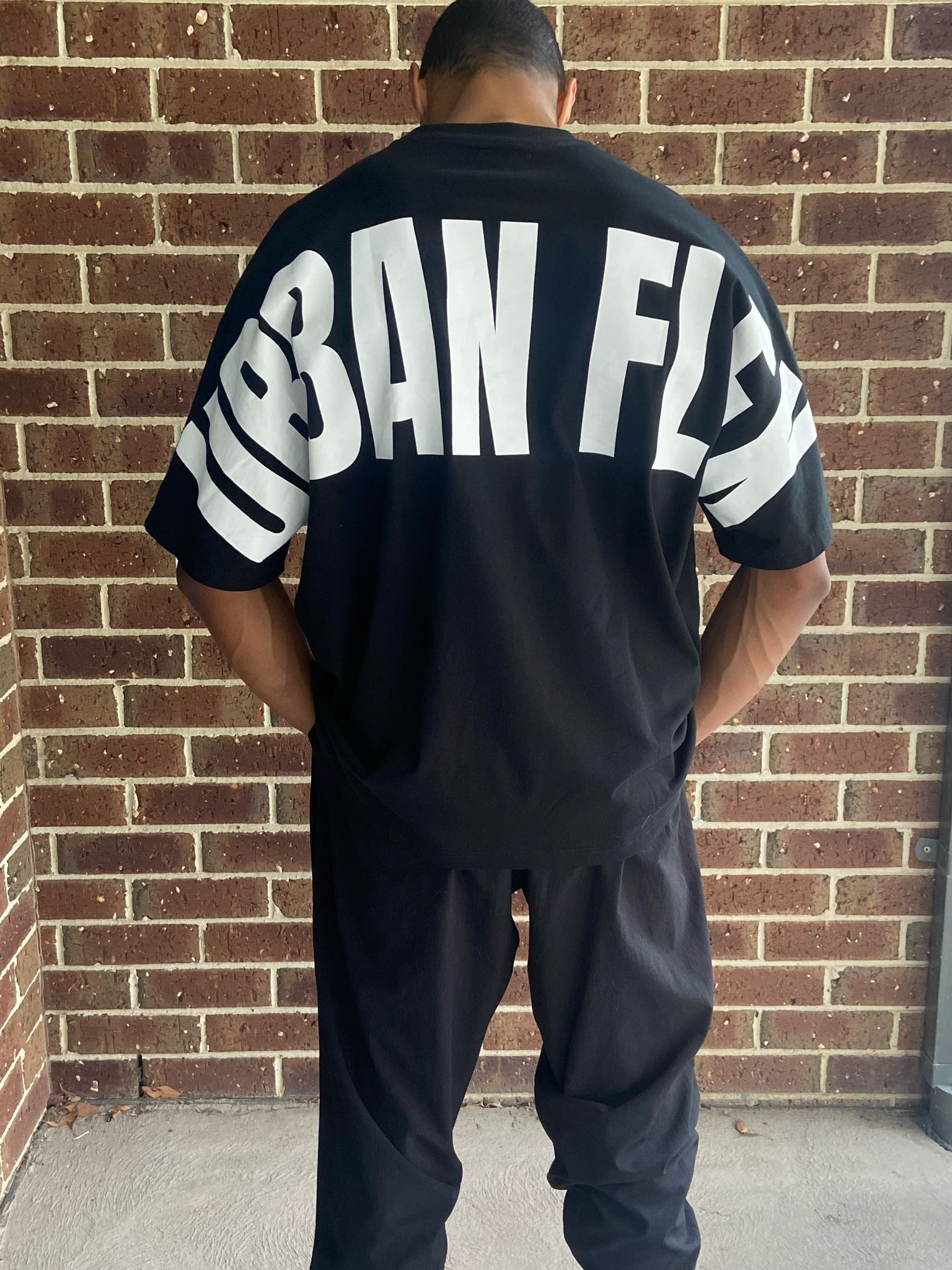 Black oversized back facing brickwall